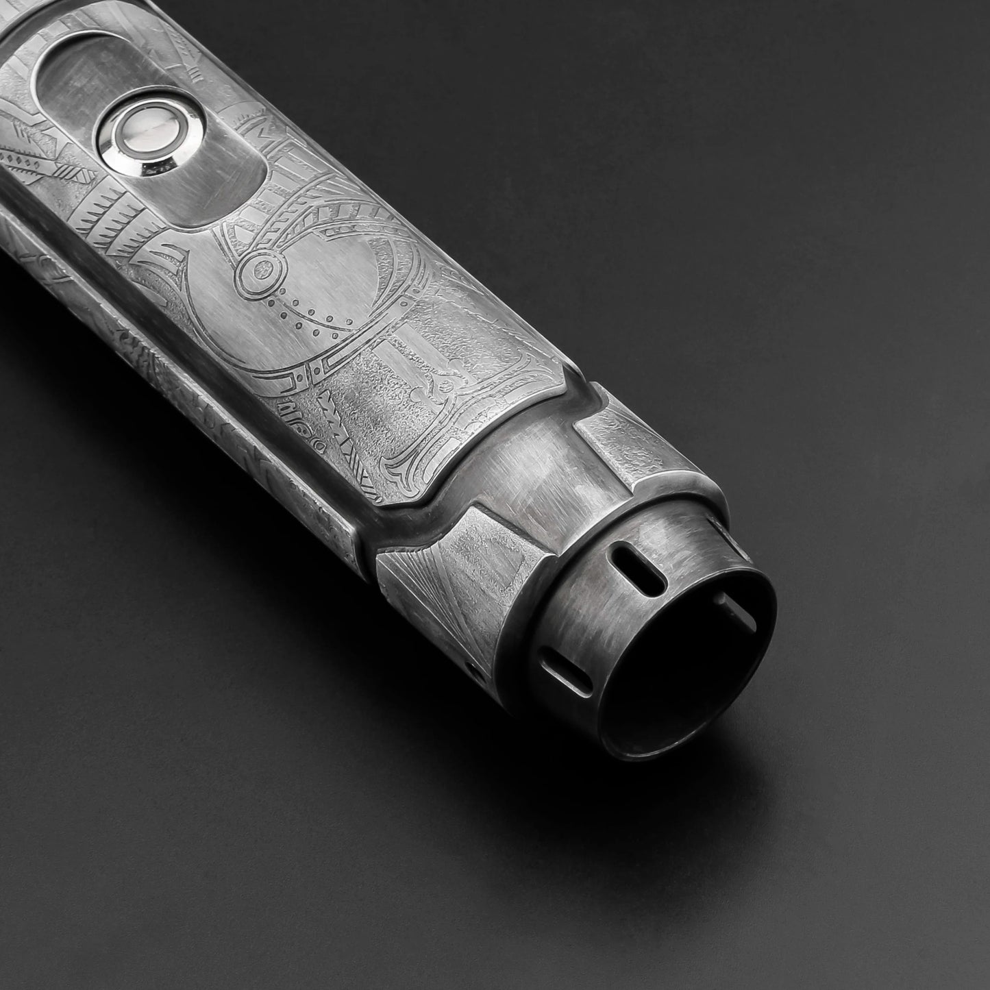 Metallic object with engraved design on a dark background